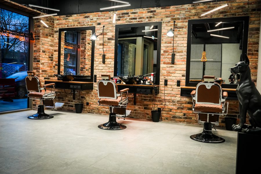 Barbers Lab - wnętrze salonu: trzy fotele barberskie, ceglana ściana i lustra